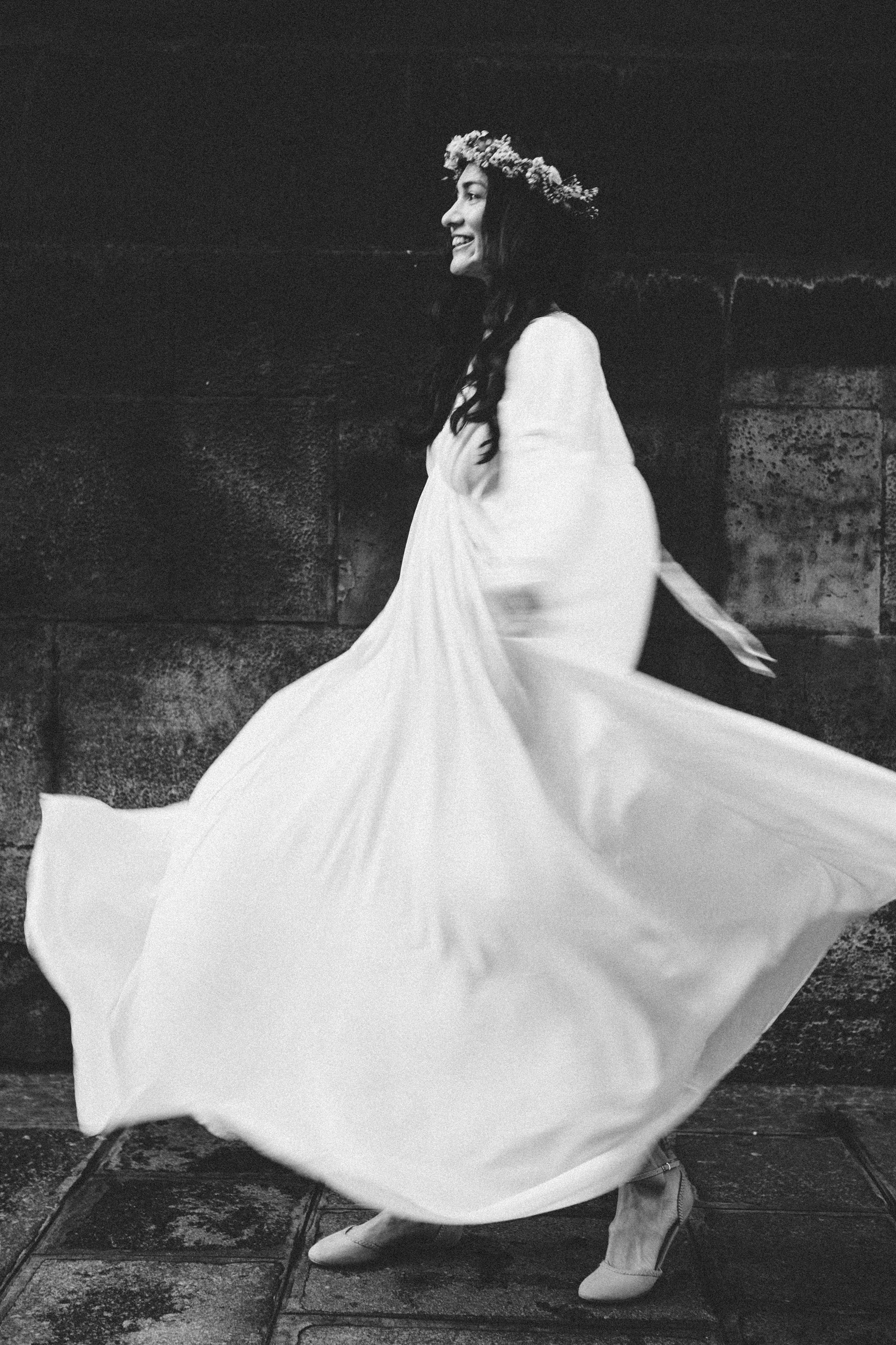 Black and white film noir portrait of a woman with a flowing white dress on a Paris street, atmospheric photography by Carla Coulson