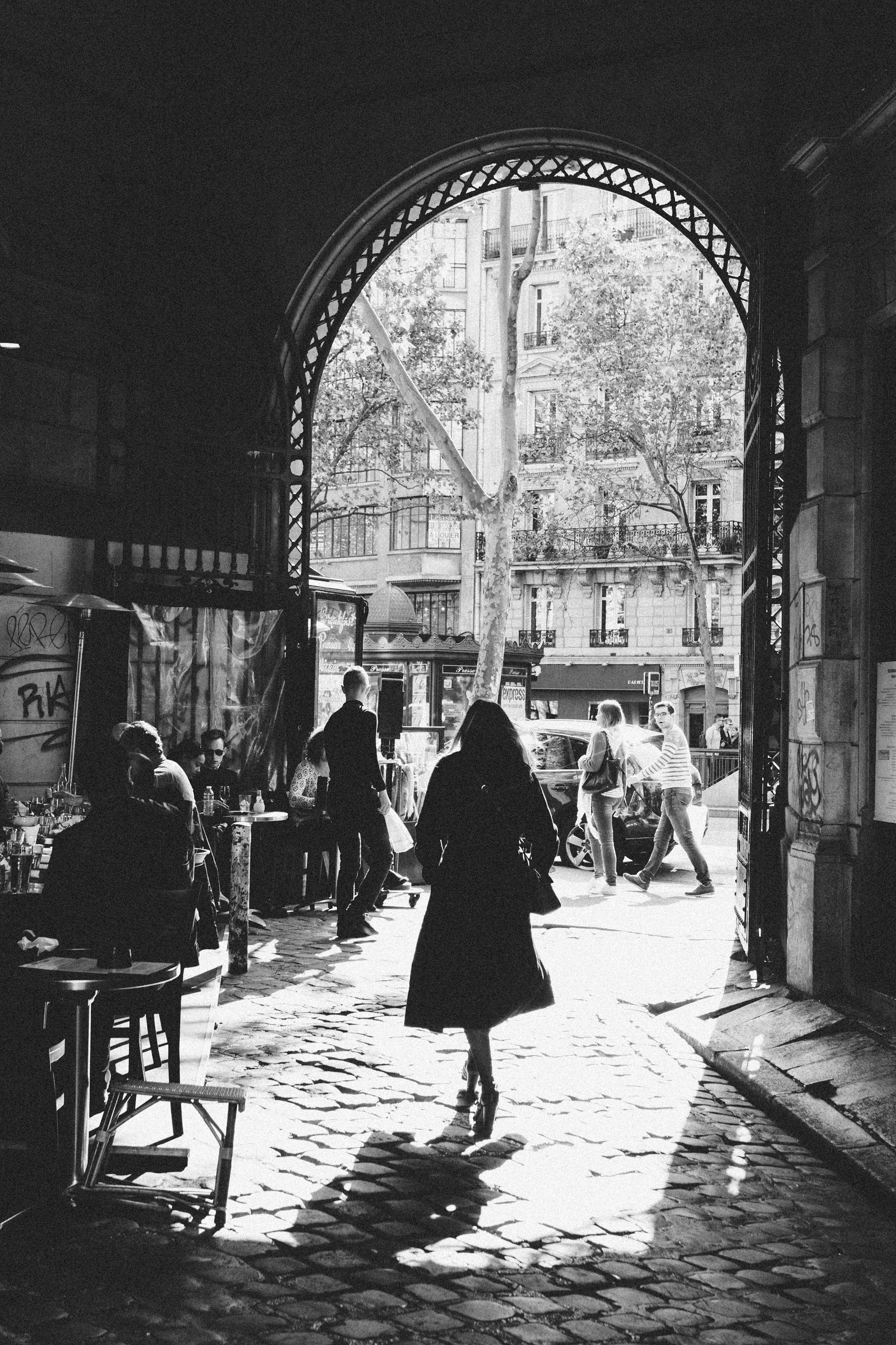 Atmospheric monochrome portrait of a woman in a Parisian alley, film noir photography by Carla Coulson