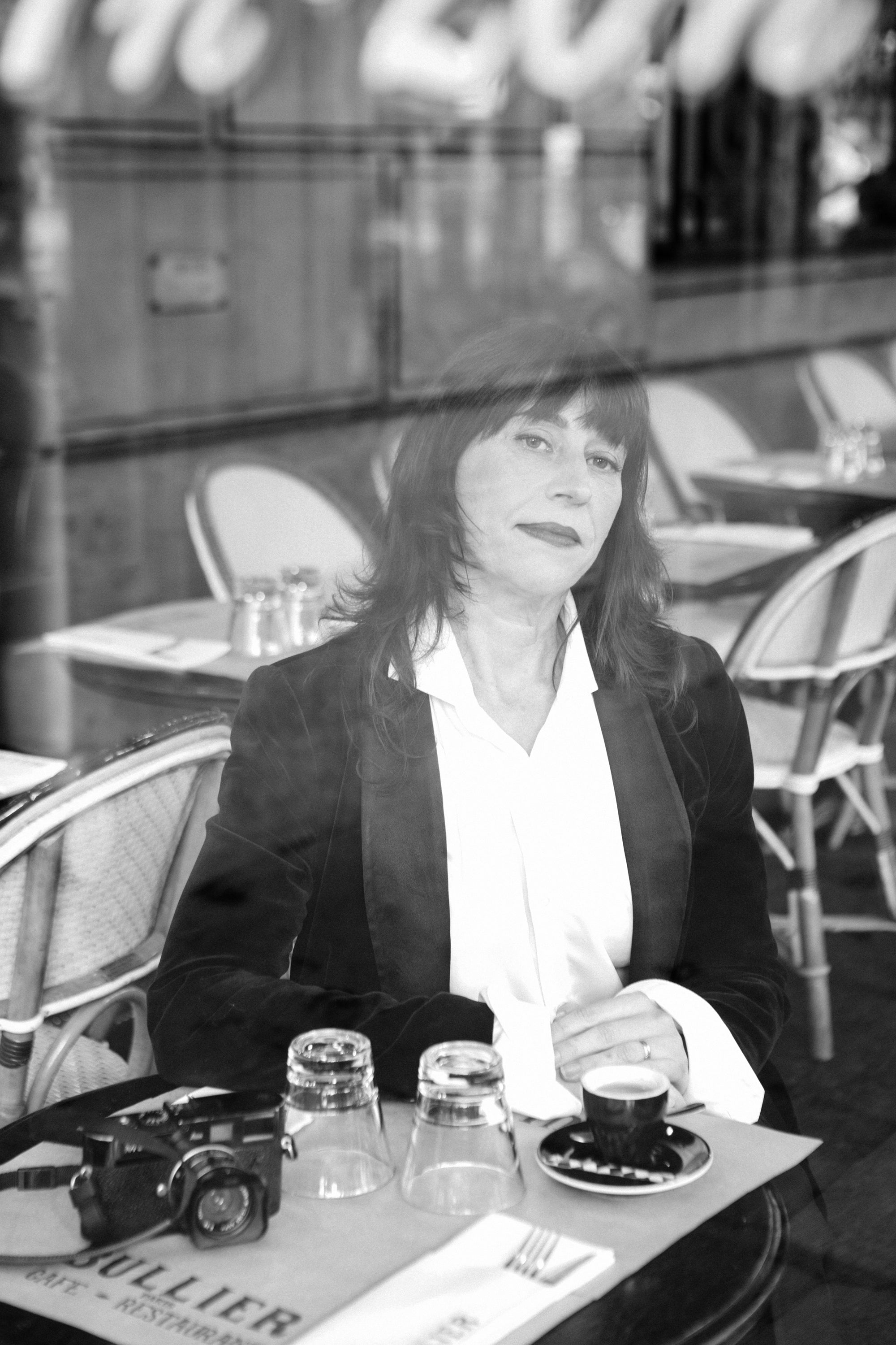 Evocative film noir portrait of a woman in a Paris cafe, monochrome photography by Carla Coulson