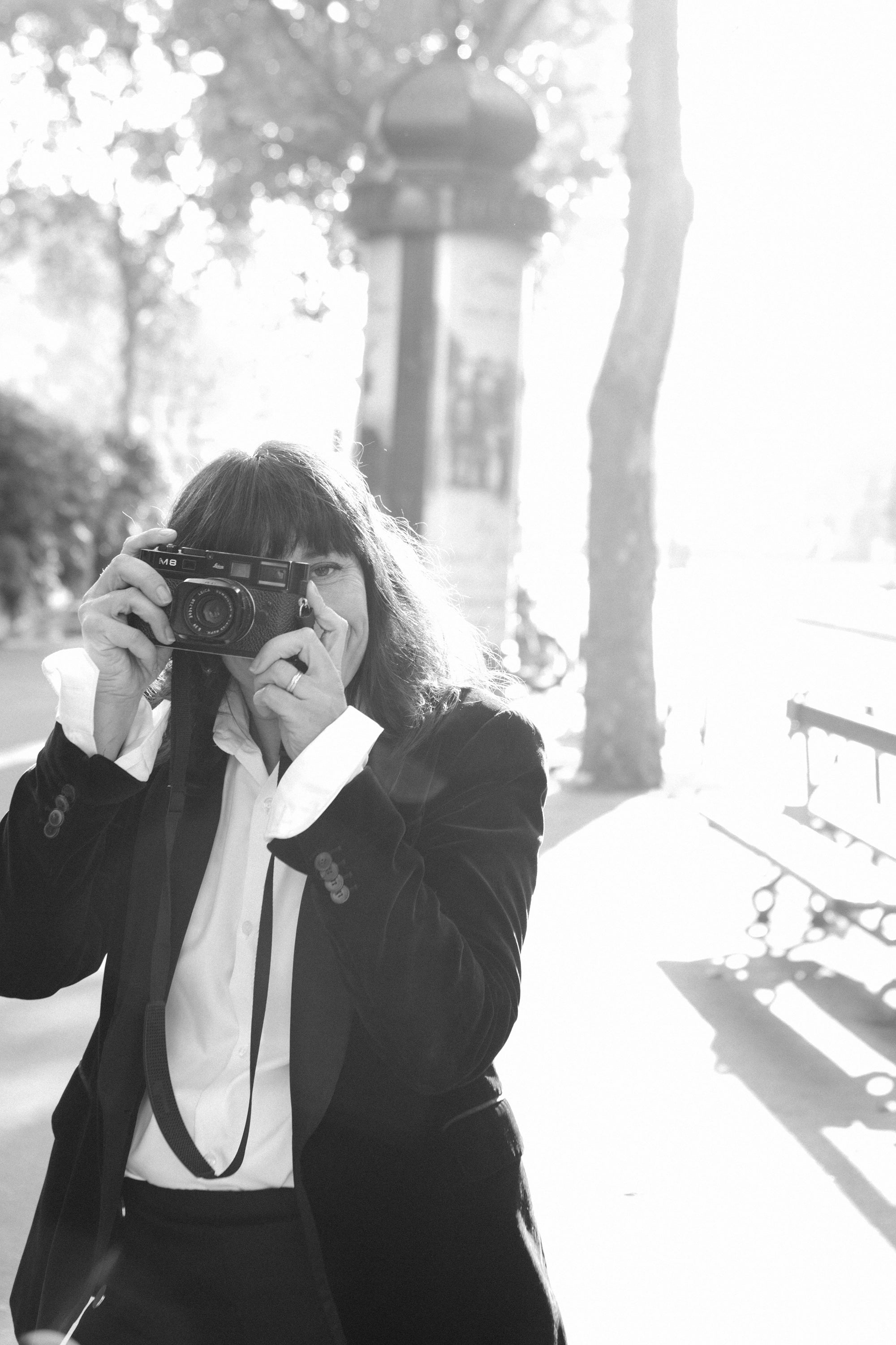 Moody black and white film noir portrait of a woman with a camera in Paris, atmospheric photography by Carla Coulson