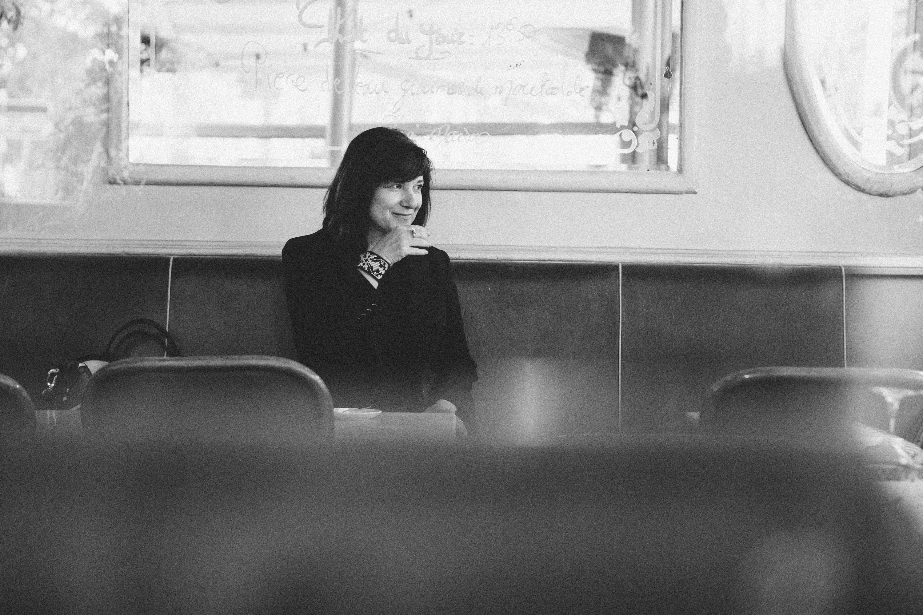 Cinematic wide-format film noir portrait of a woman in Paris, dramatic monochrome photography by Carla Coulson