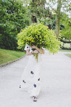 Wild Child is a photo of a girl in Jardin du Luxembourg in Paris with a beautiful bouquet of green blooms and is part of a limited edition series named Young Girl in Bloom by photographer Carla Coulson celebrating women loving and believing in themselves and building their self esteem by trusting their intuition.