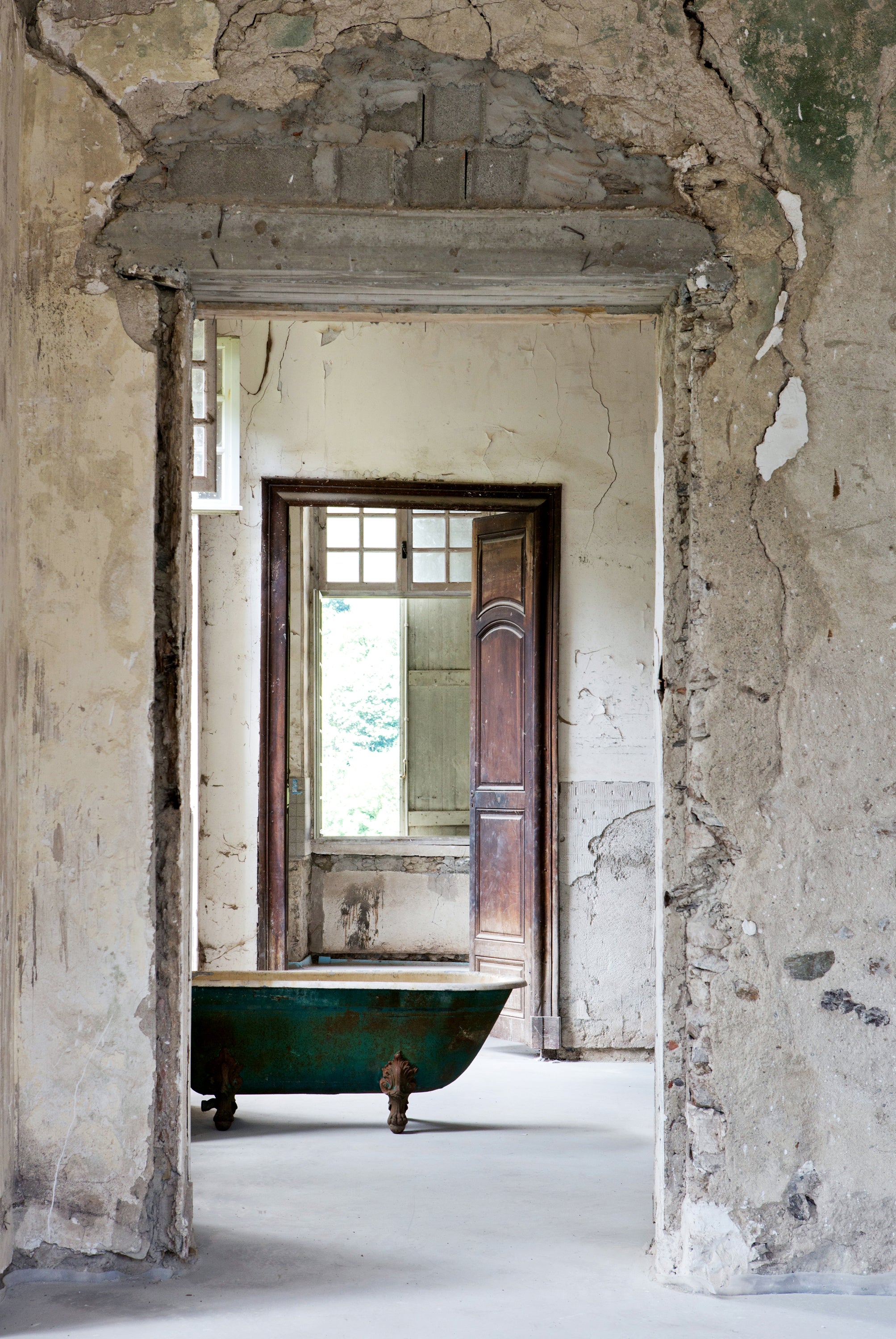 Rustic bathroom with a green bathtub in an old chateau — lifestyle photography by Carla Coulson