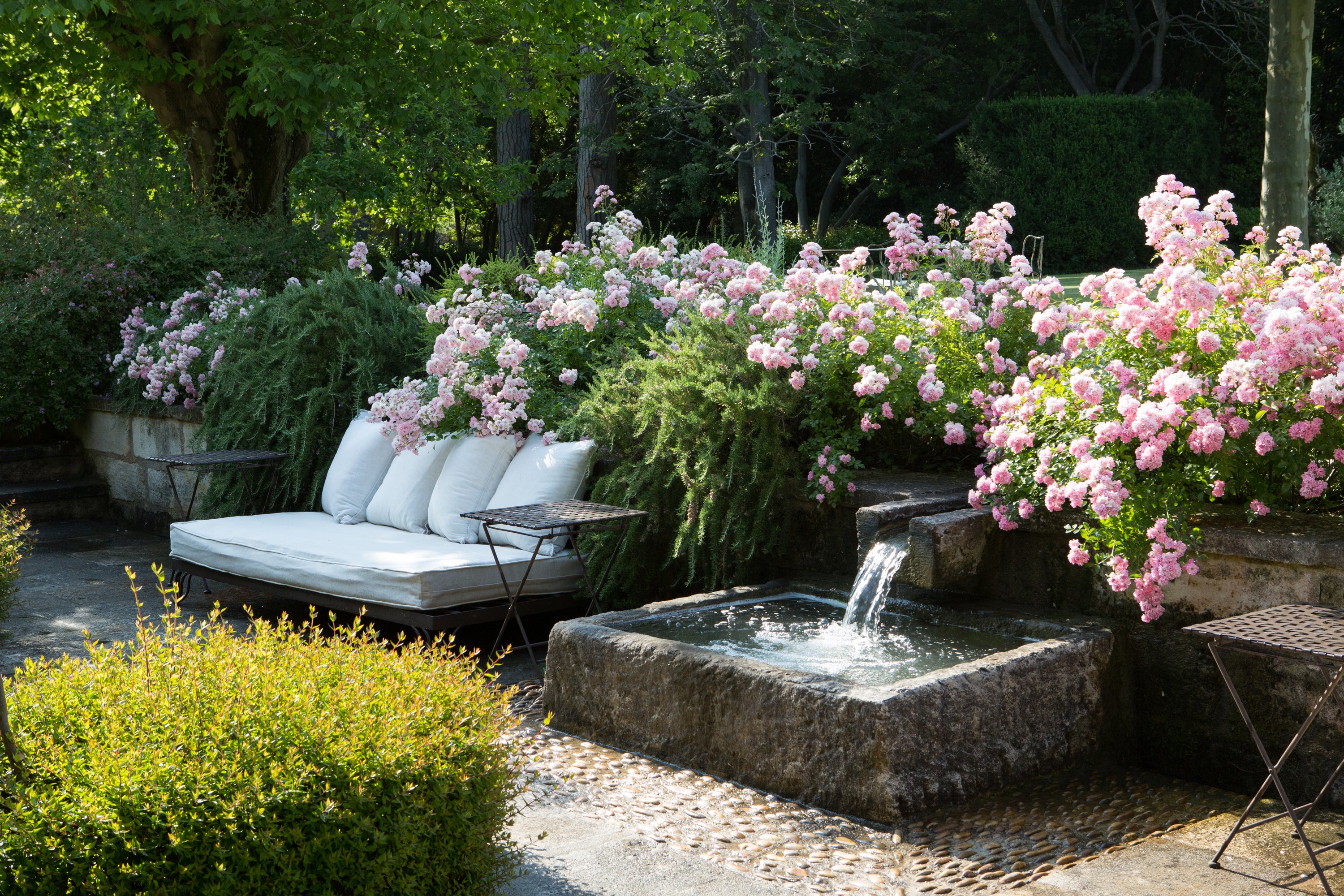Outdoor garden setting with a fountain, flowers, and seating area — European property photography by Carla Coulson
