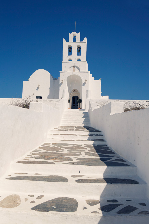 places to visit on the Greek Island of Sifnos white stone Entrance to  Zoodochos Pigi monastery on the island of Sifnos