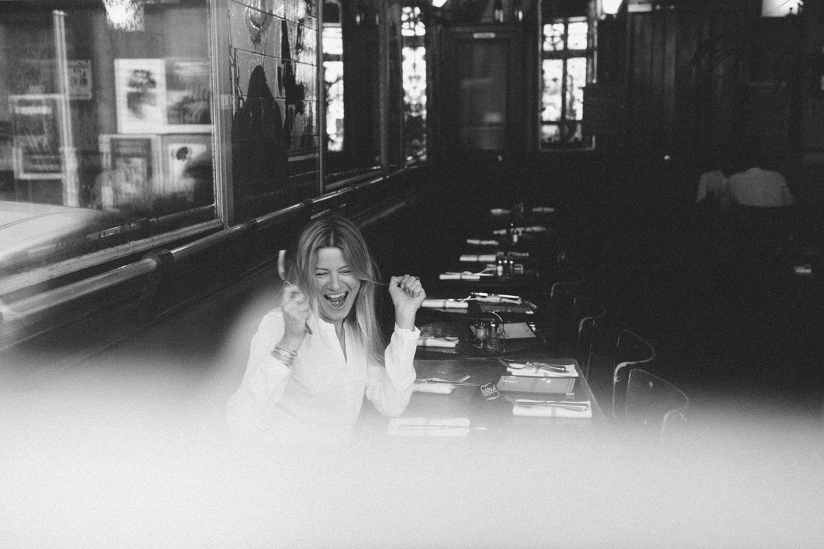 black and white photo of joyful woman in paris cafe 